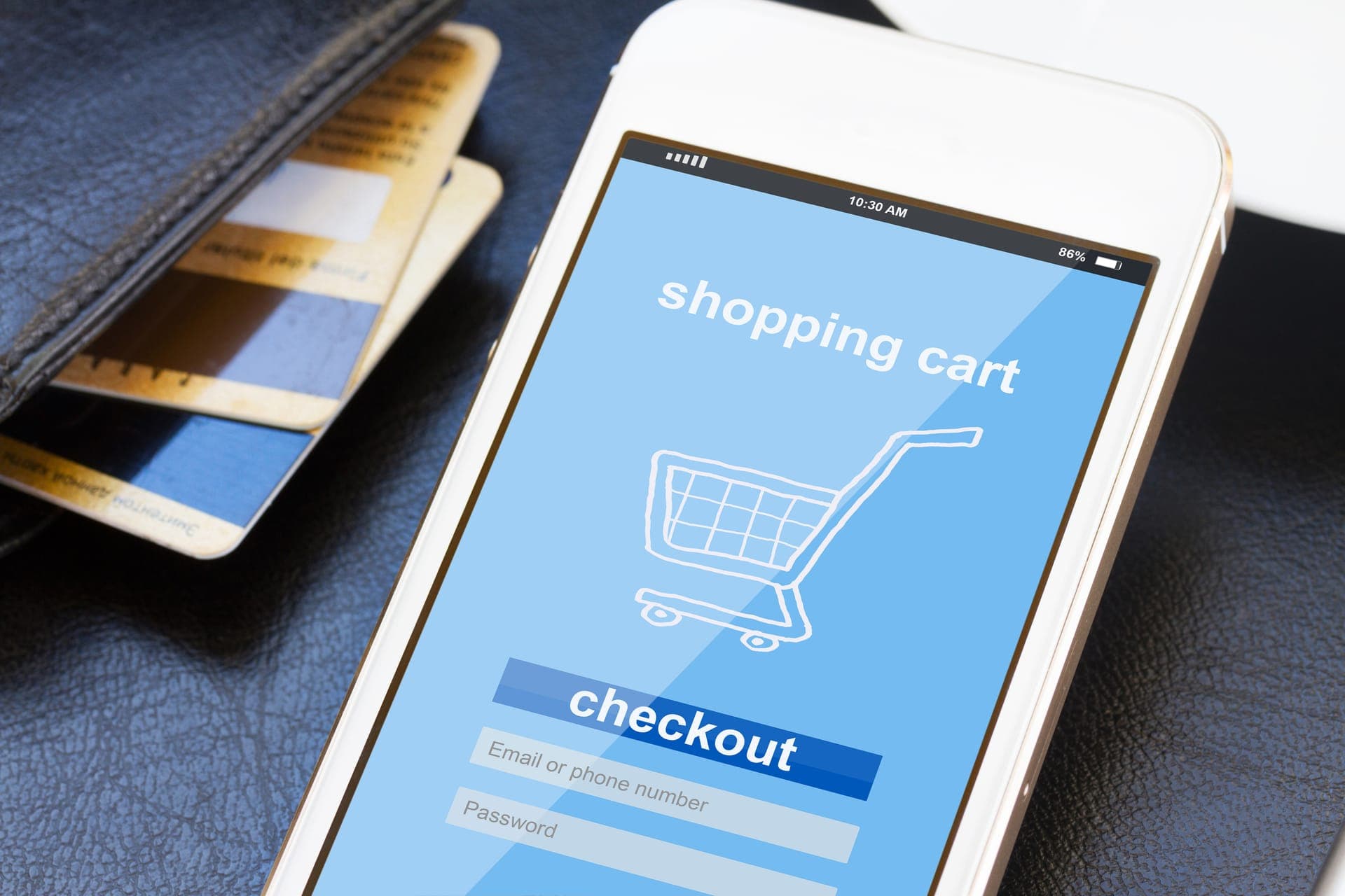 Afrekenen in een webshop op een smartphone met bankpassen ernaast