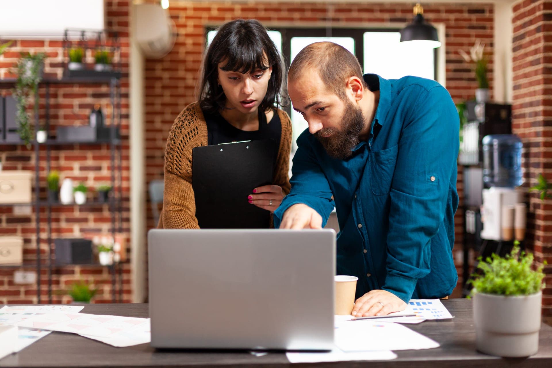 Twee ondernemers nemen samen de cijfers van hun website door op een laptop