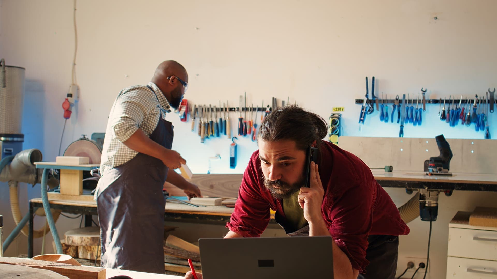 Local business owner in his workshop discussing his website by phone